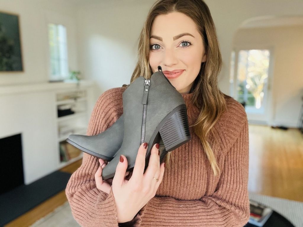 woman holding gray booties in her arms