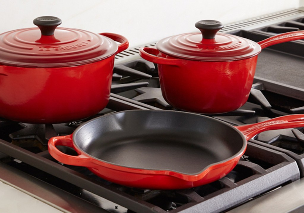 red pots and pans with lids on gar stovetop