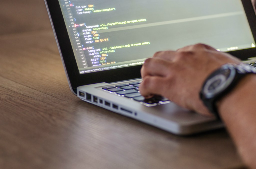 man coding on laptop