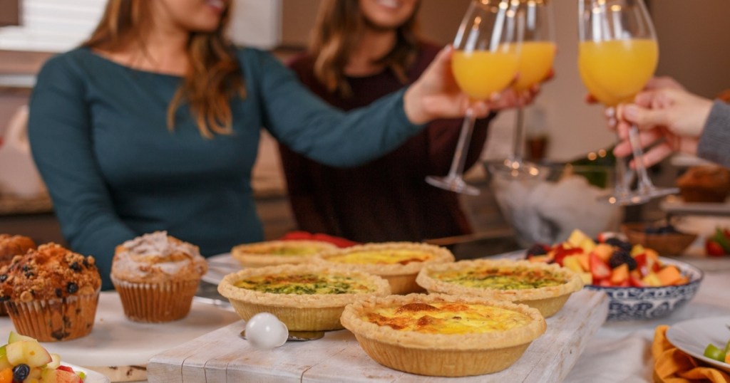 women toasting with orange juice over brunch