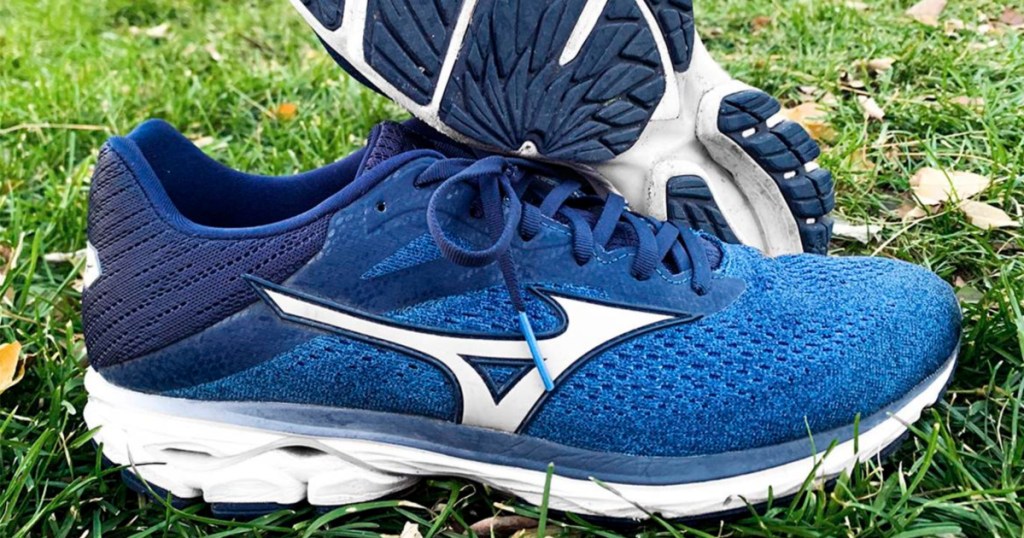 a pair of mizuno mens wave rider running shoes in grass