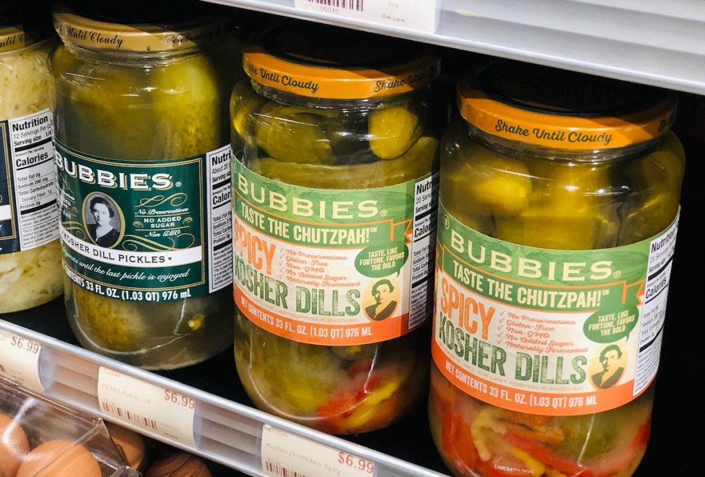 row of pickle jars on store fridge aisle 