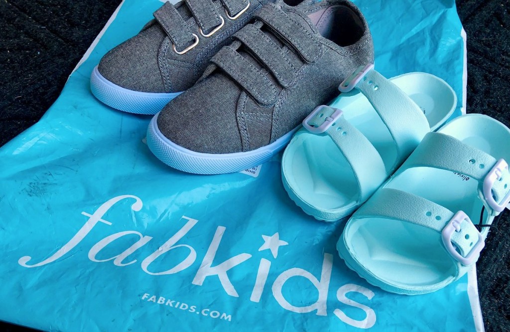 gray tennis shoes and blue sandals on blue fabkids bag