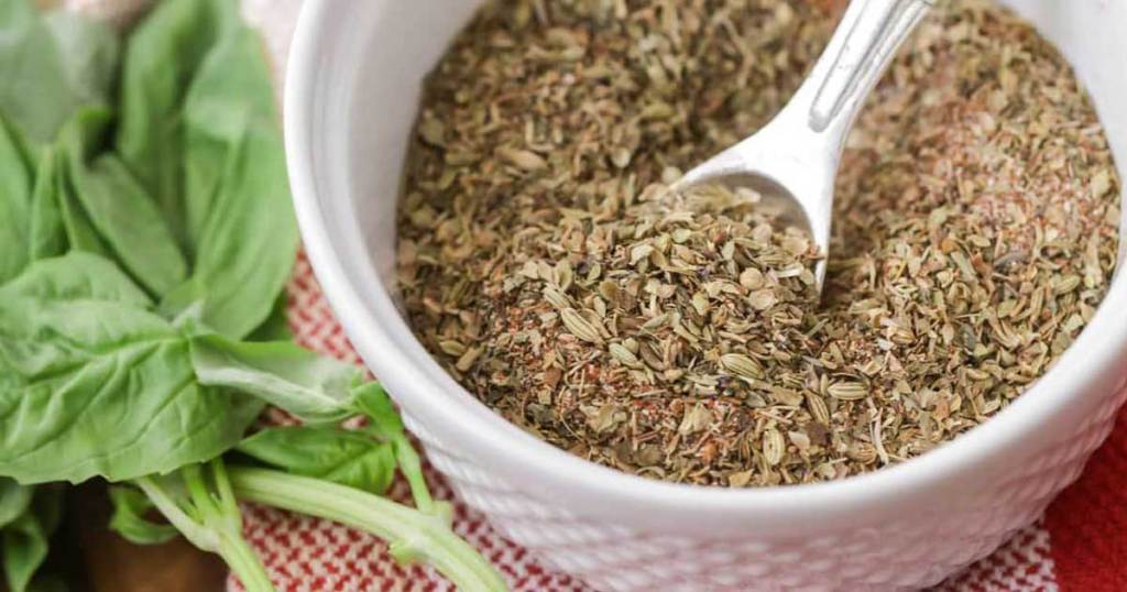 bowl full of spices and seasonings with a spoon in it