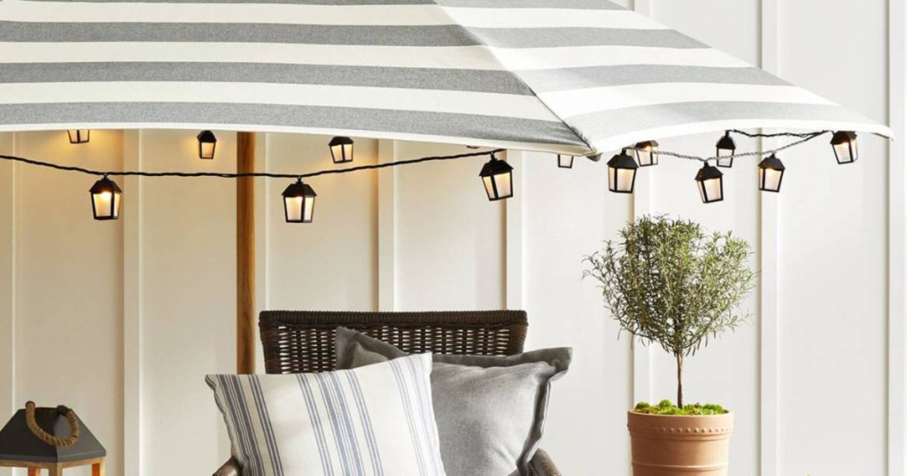 lantern lights hanging off striped patio umbrella