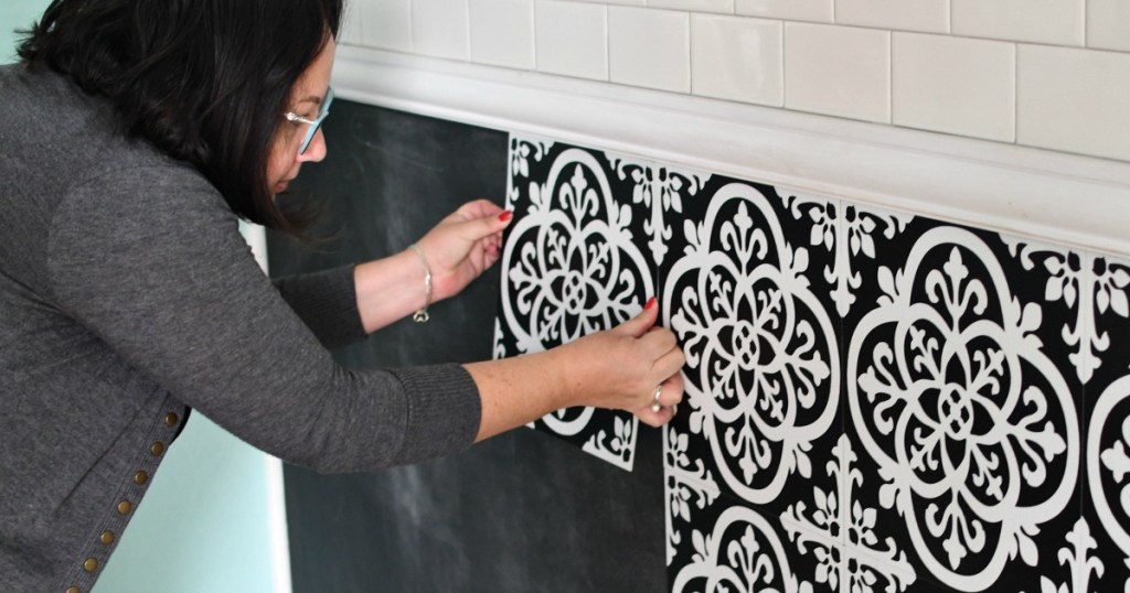 woman installing peel and stick floor pops tile