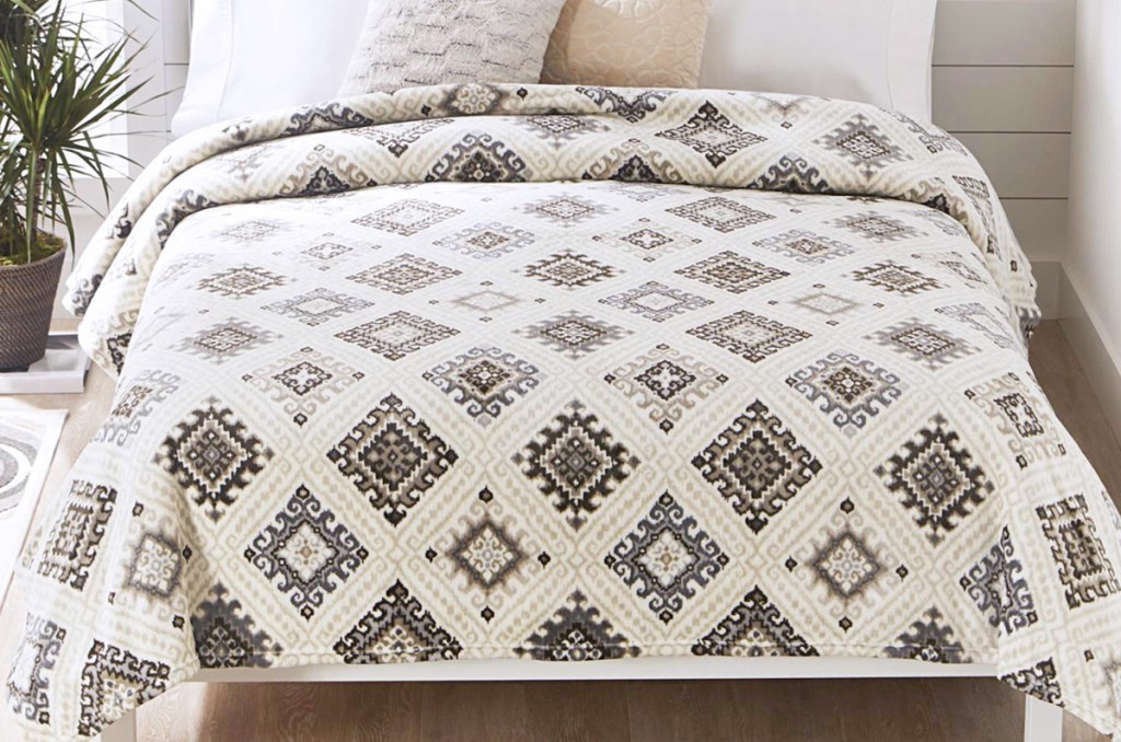 white plush blanket with brown diamond pattern on a bed