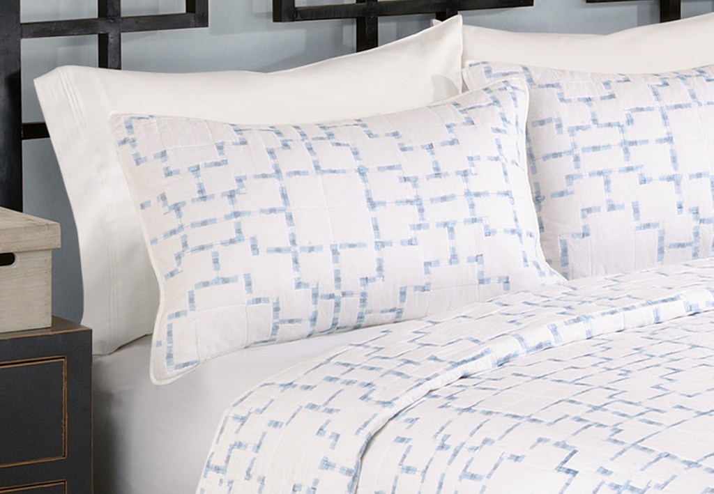 white pillow shams with light blue print on a bed with matching duvet