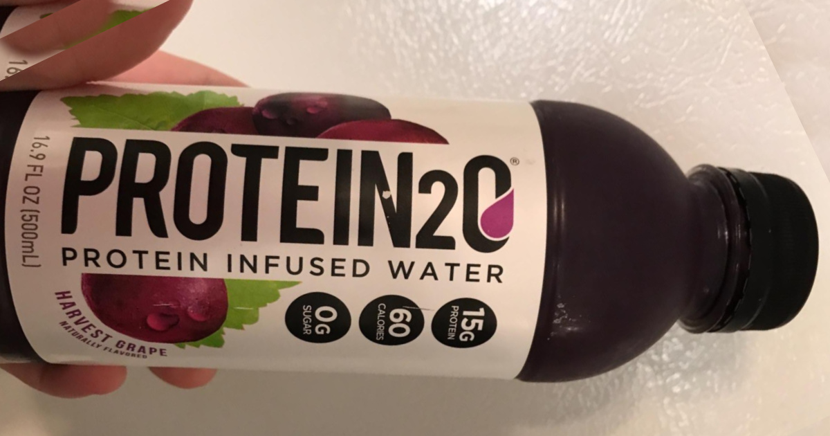 Hand holding a bottle of grape flavored protein water