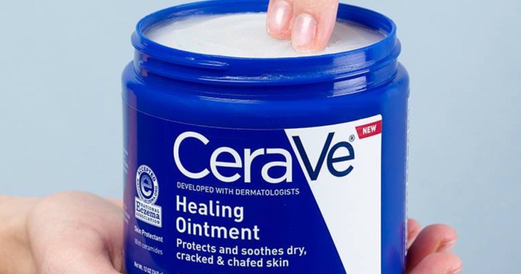 hand holding a jar of cerave ointment and two fingers dipping into the jar