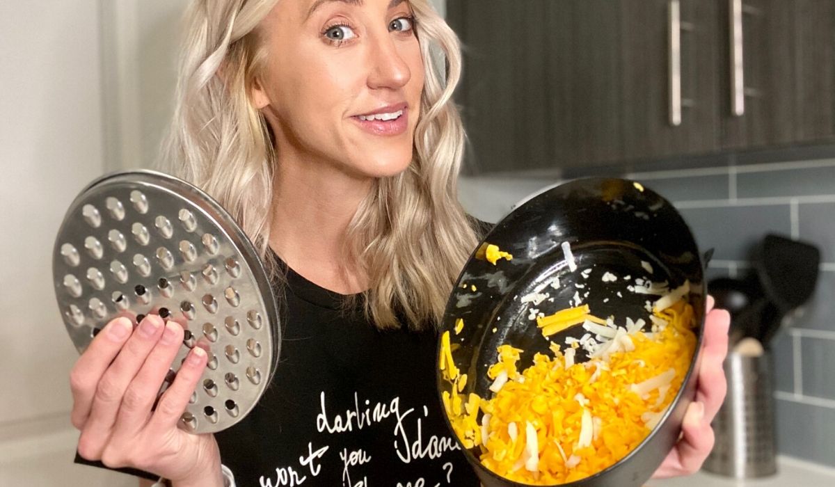 Woman holding Amazon cheese grater with grated cheese in the storage compartment