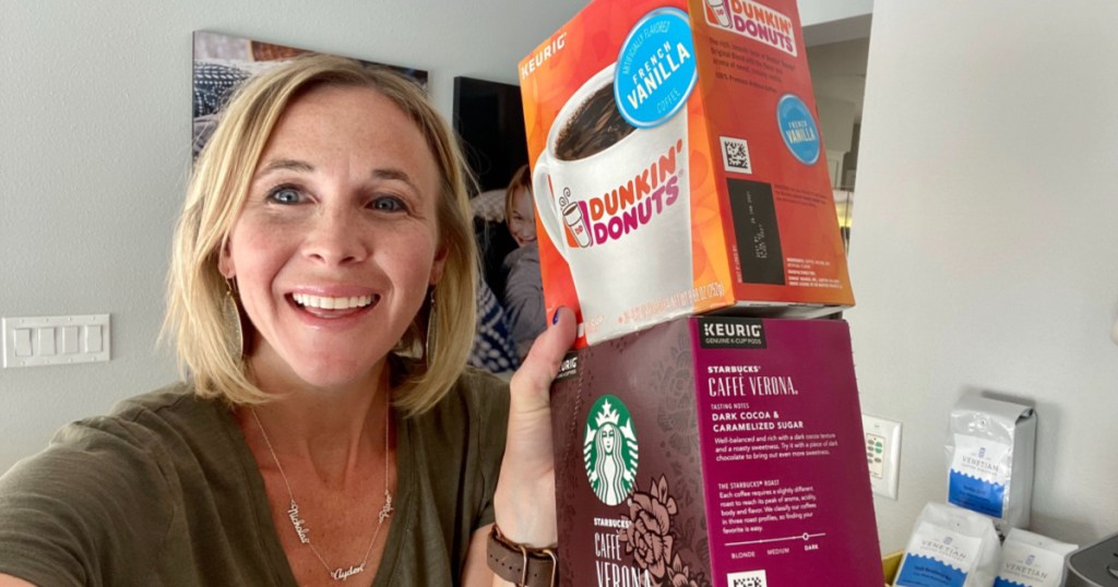 woman smiling and holding two boxes of coffee pods