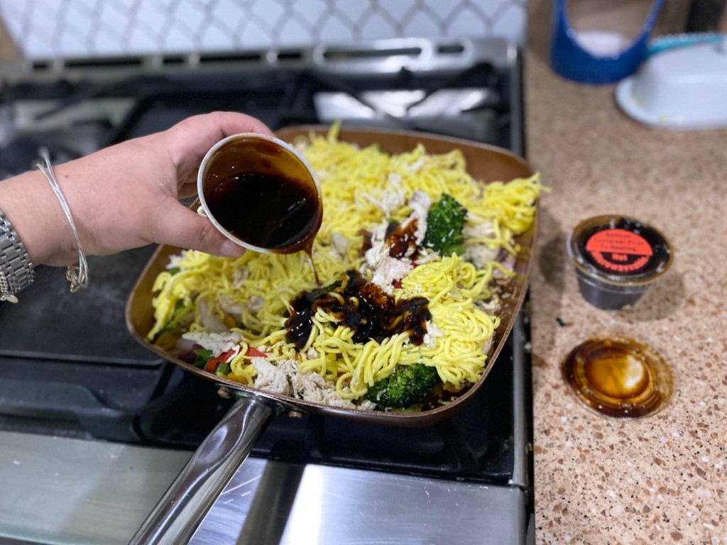 pouring soy sauce onto stir fry