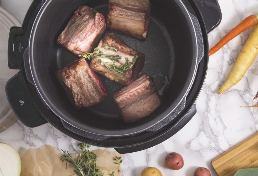 inside view of pressure cooker cooking pieces of meat