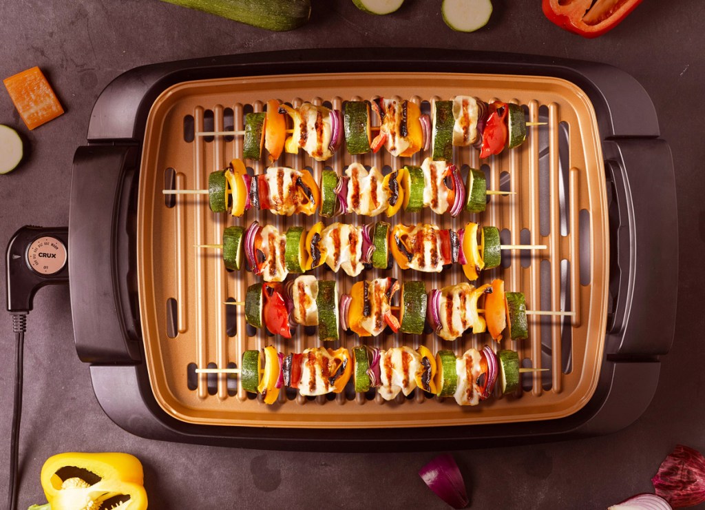 copper indoor smokeless grill with vegetable kebabs on it