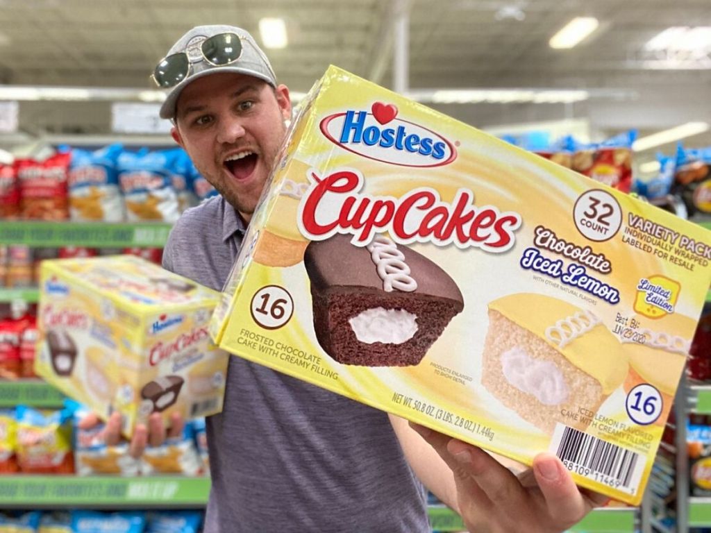 man holding two giant boxes of Hostess cupcakes