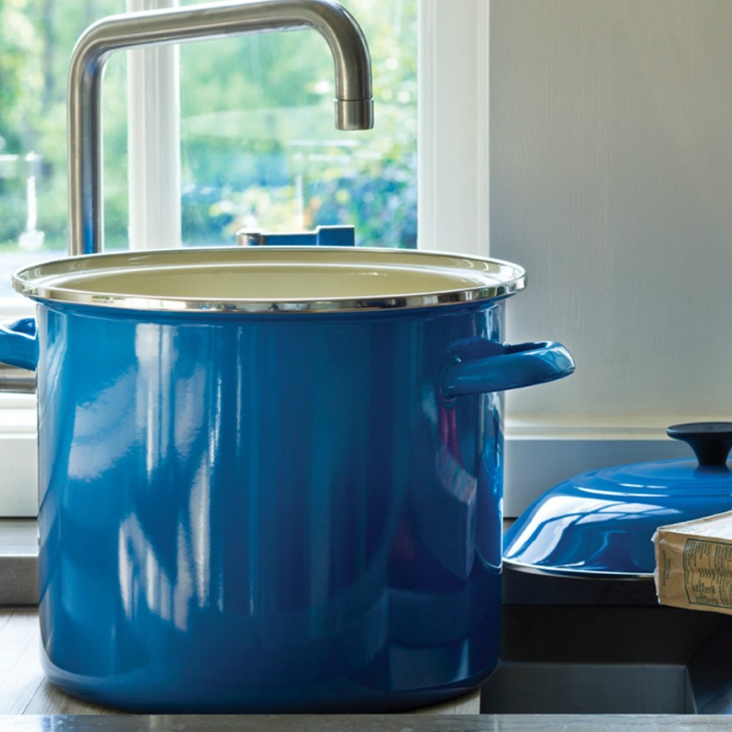 blue LeCreuset stock pot under a sink in a kitchen