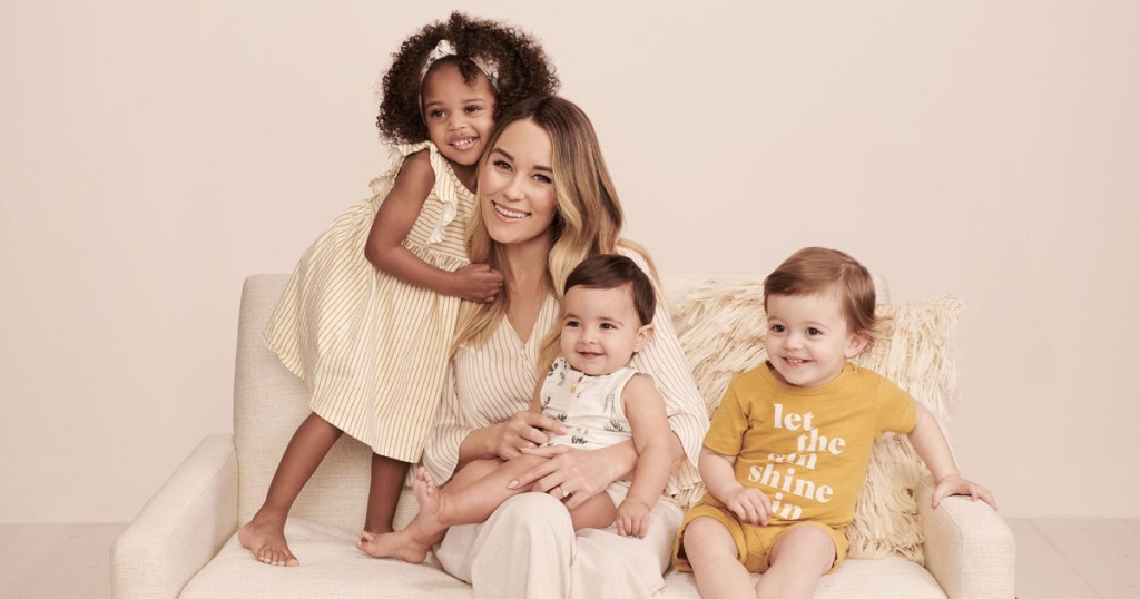 woman sitting on couch with three babys and toddlers in little co by lauren conrad outfits