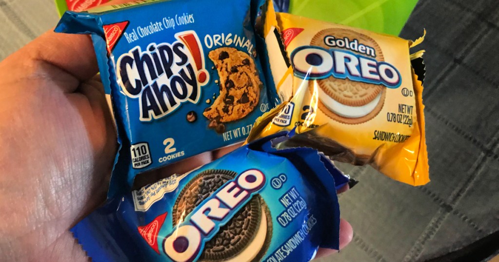 hand holding nabisco cookies chips ahoy, golden oreos, and regular oreos