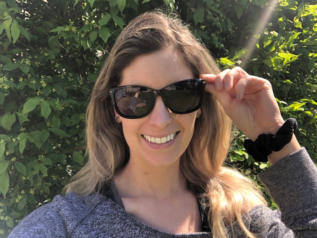 person holding onto sunglasses