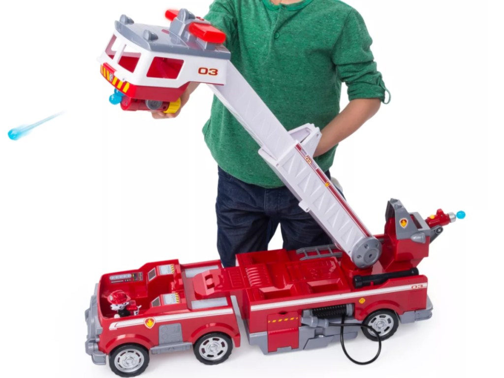 little boy playing with big paw patrol fire truck