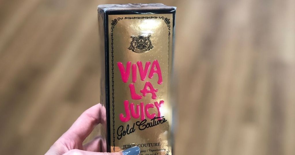 woman's hand holding box of perfume at store