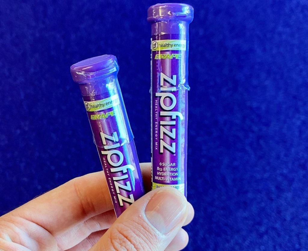 hand holding two tubes of Zipfizz Drink Mixes