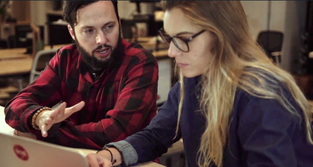 man and woman using laptop to access udemy