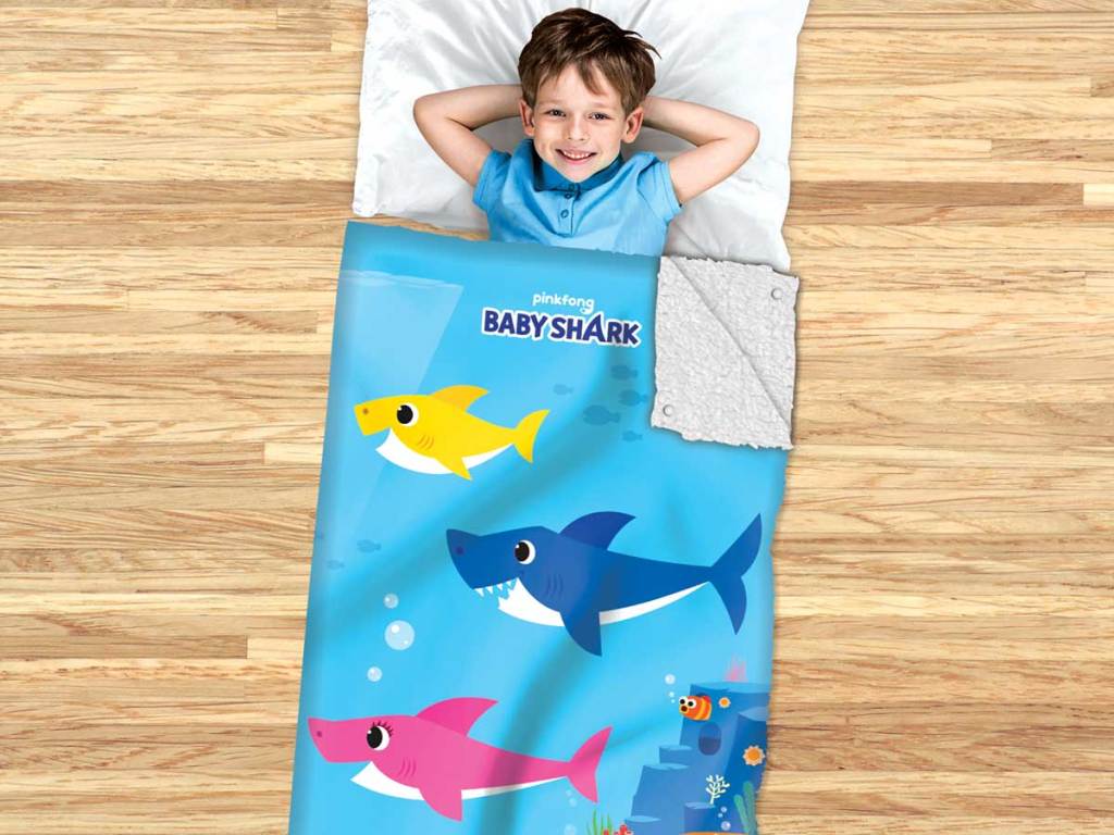 little boy sleeping in a baby shark sleeping bag