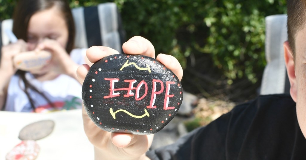 boy holding a kindness rock