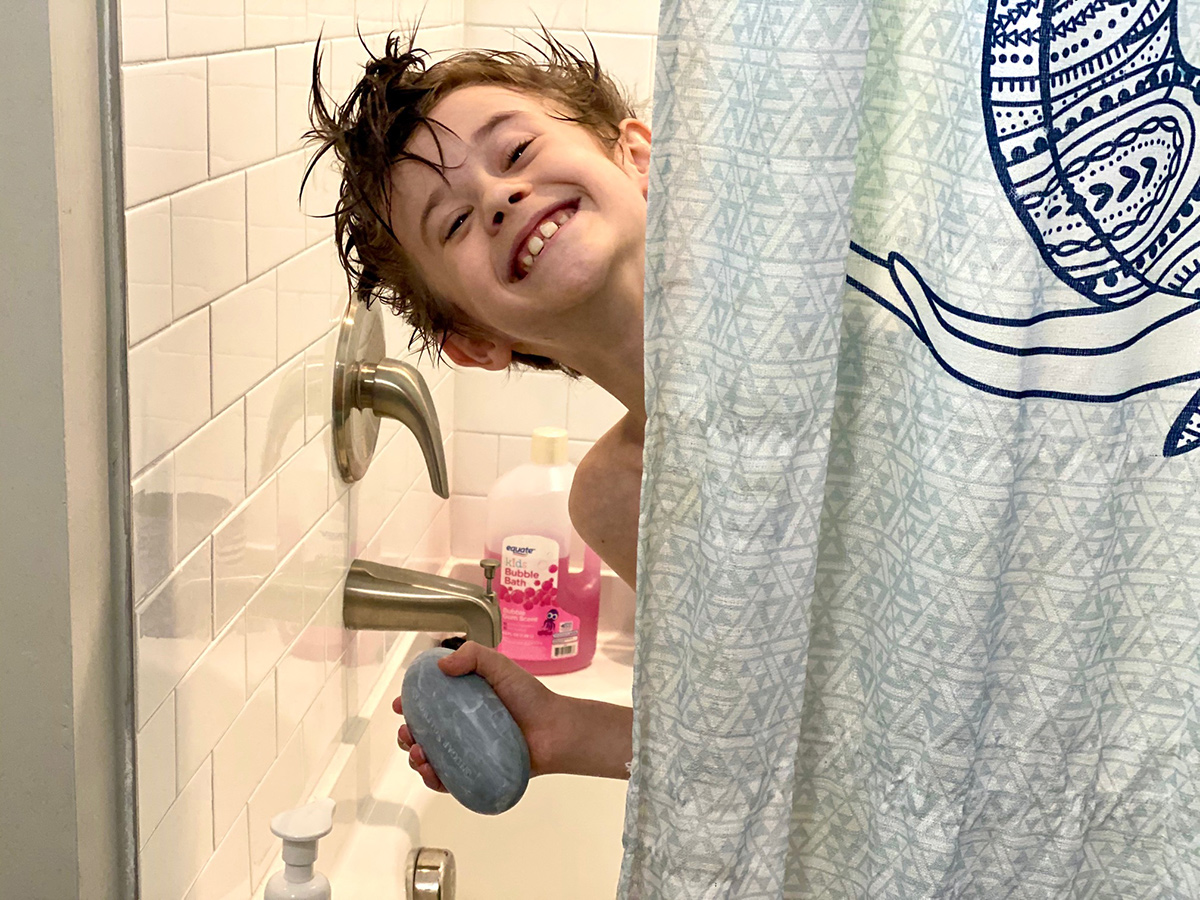 young boy holding shugar soapworks bar of soap