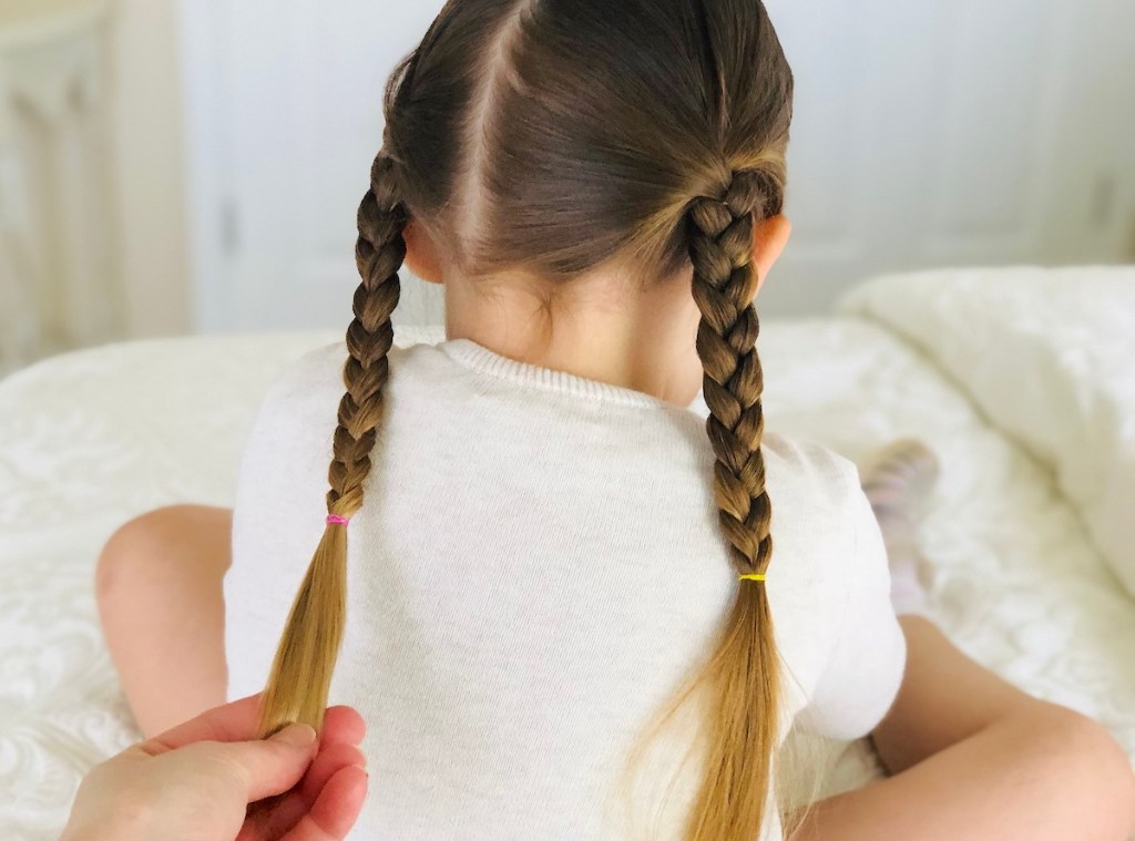 hand holding a braid on girls head