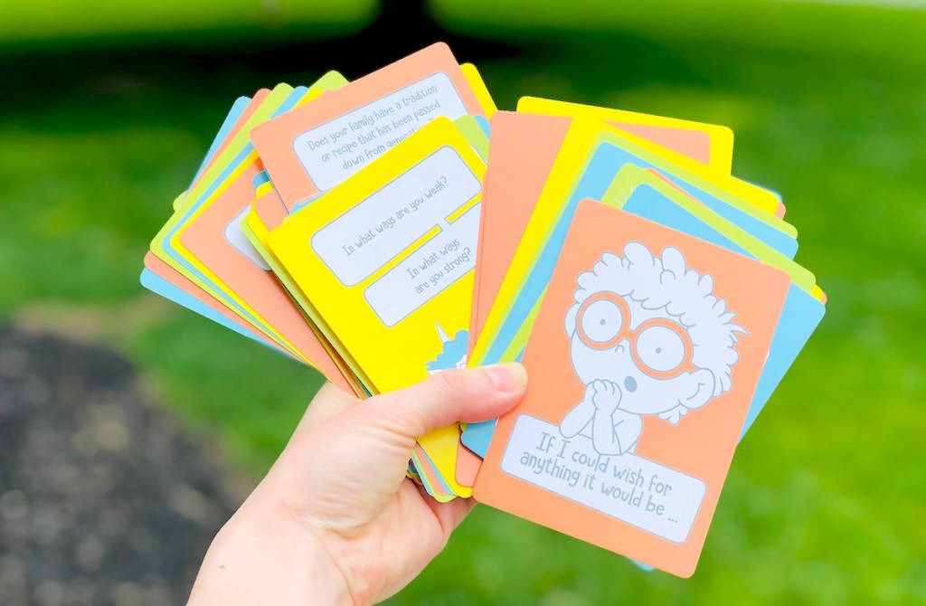 hand holding a colorful deck of conversation cards