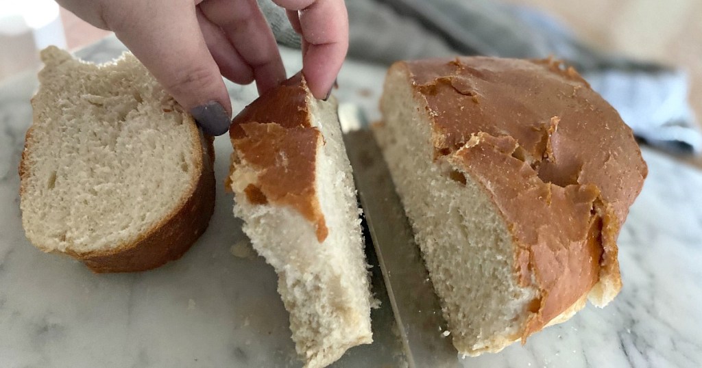 cutting into a loaf of french bread