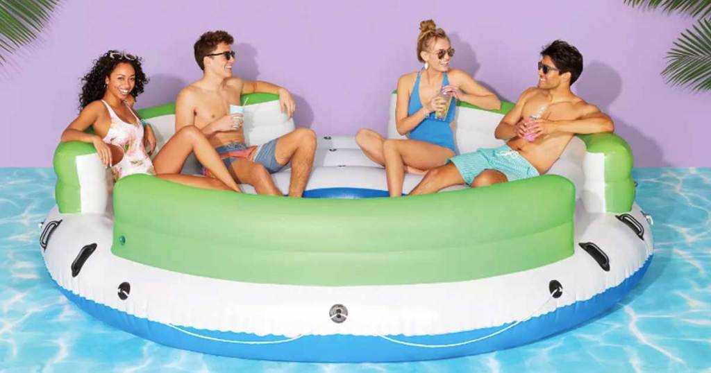 four people sitting in a large circular pool float