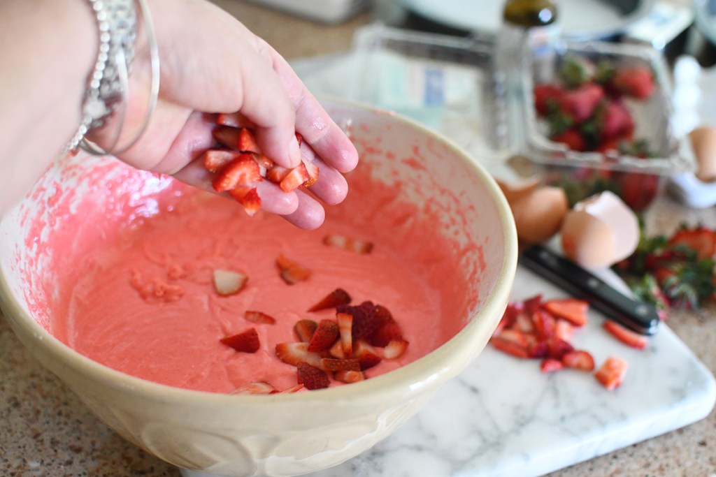 adding strawberries to cake batter