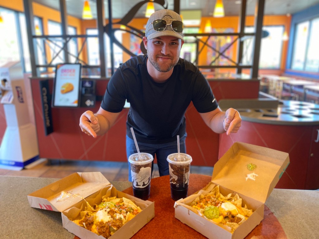 man pointing at Taco Bell nachos 