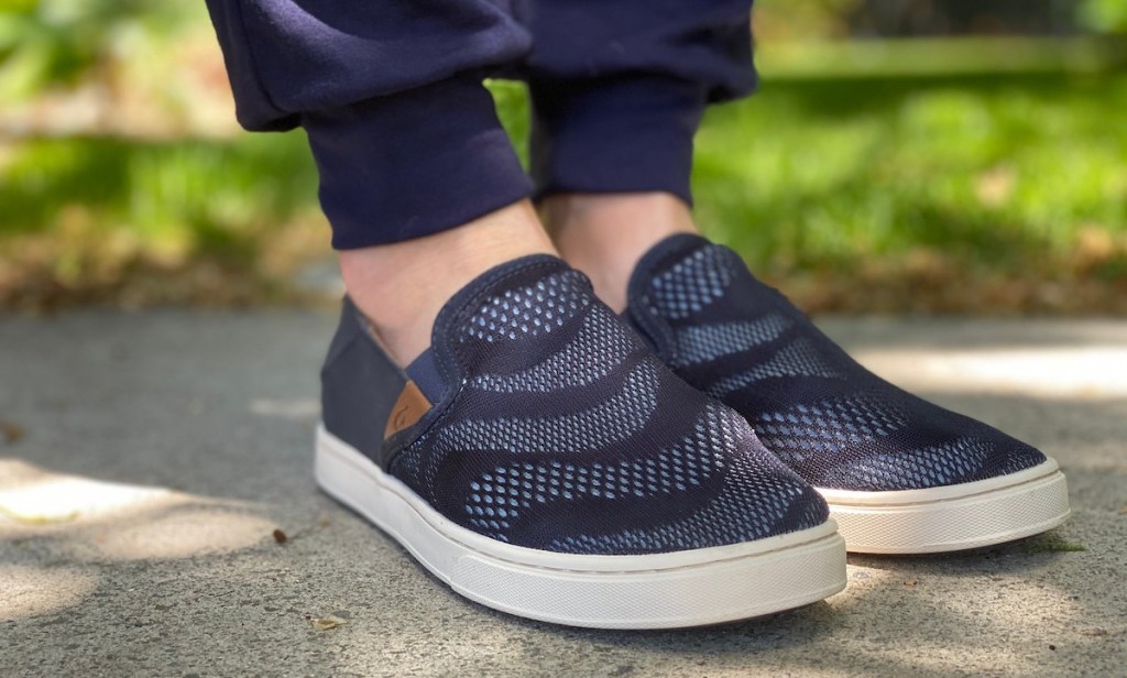 feet wearing blue loafer slip on shoes on concrete outside