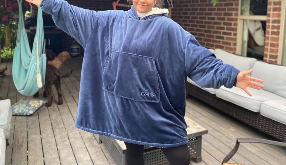 person wearing blue comfy wearable blanket on deck outside