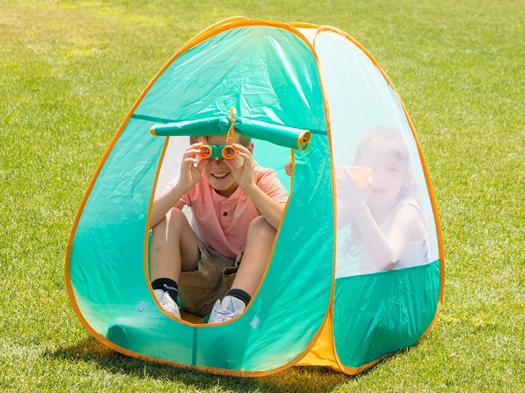 boy using binoculars in tent