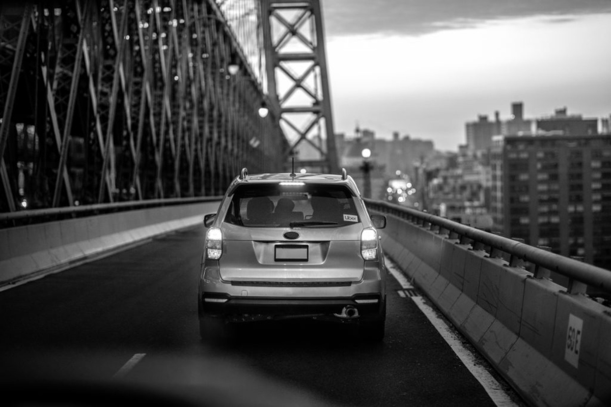 rear of Uber car driving over bridge