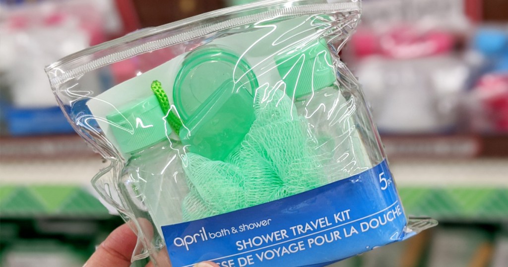 green travel shower kit with empty bottles pill organizer, and loofa, in a clear pouch