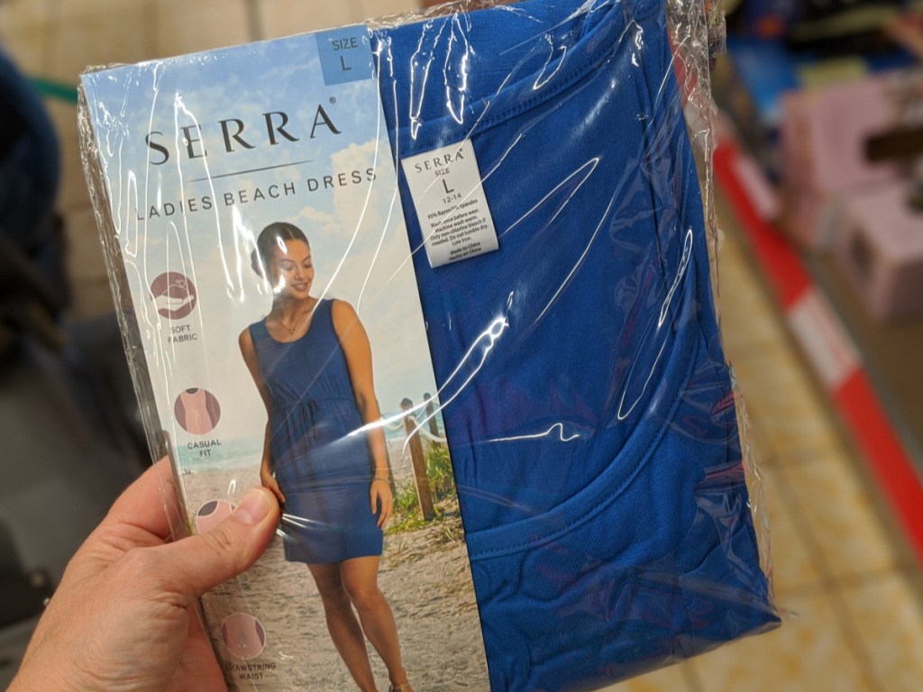 hand holding women's blue sun dress in-store at aldi 