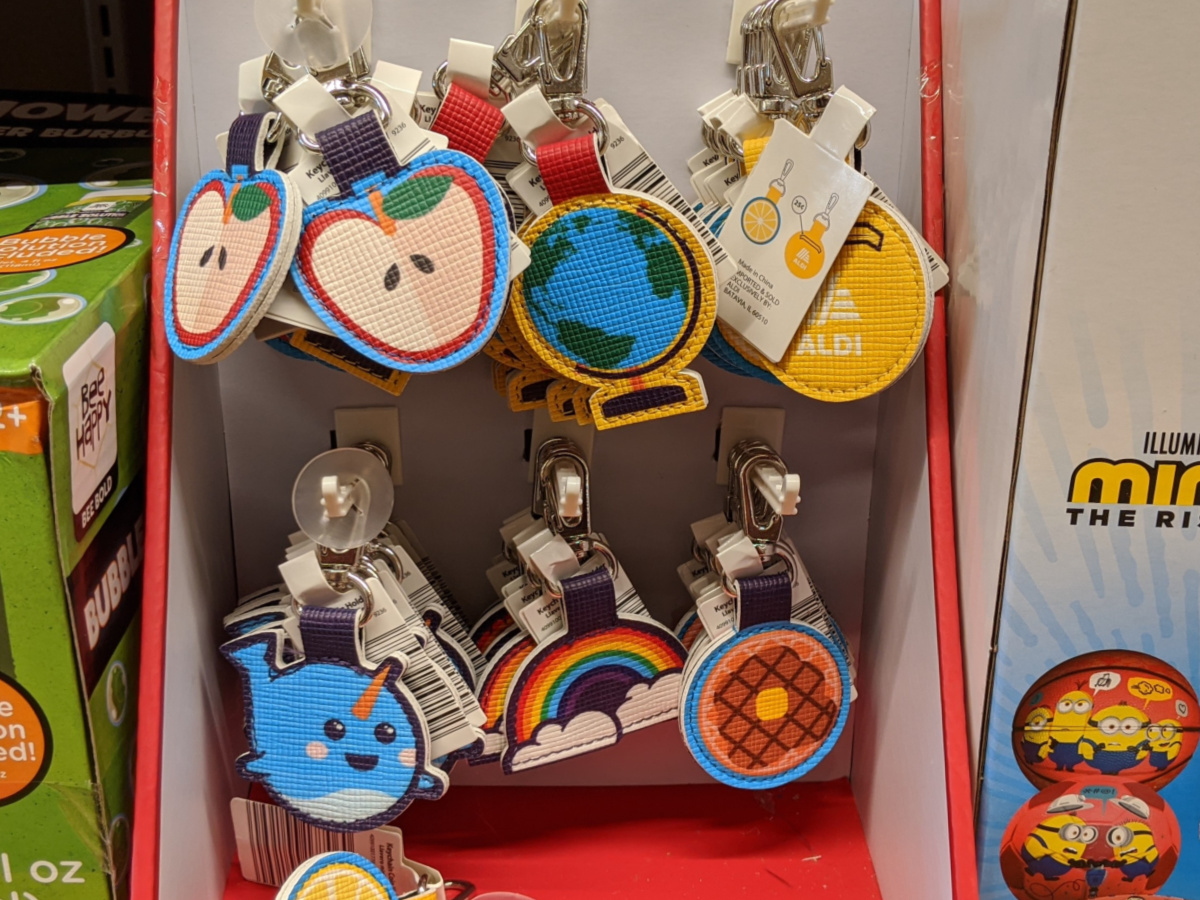 apple globe narwhal rainbow and waffle key chain coin holders hanging on display in sore