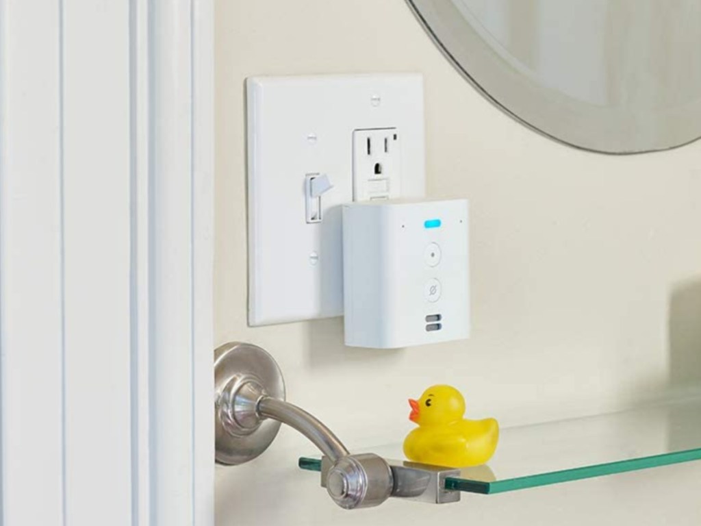 white plug-in mini smart speaker in outlet in bathroom