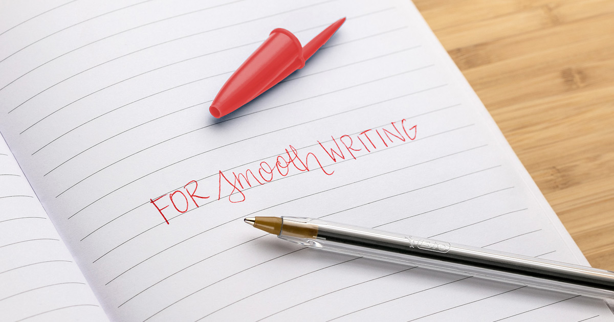 pen and red cap laying on notebook with "for smooth writing" printed in red ink on page