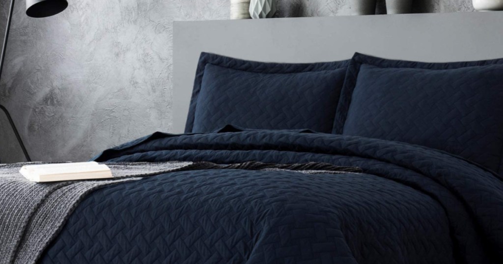 navy blue quilt set on a grey bedframe