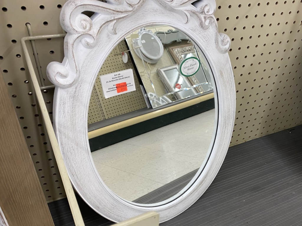 ornate oval white wall mirror in store
