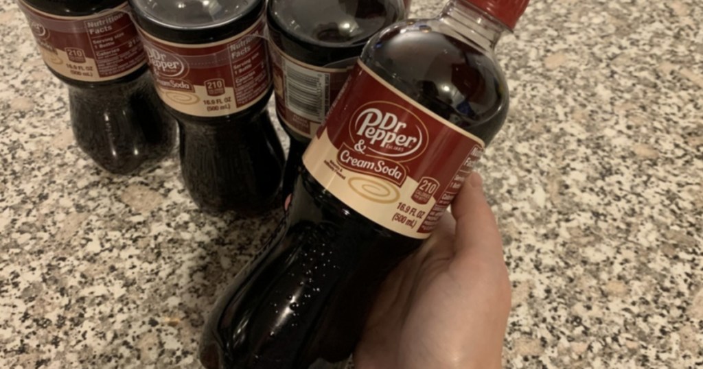 hand holding a dr. pepper & cream soda bottle