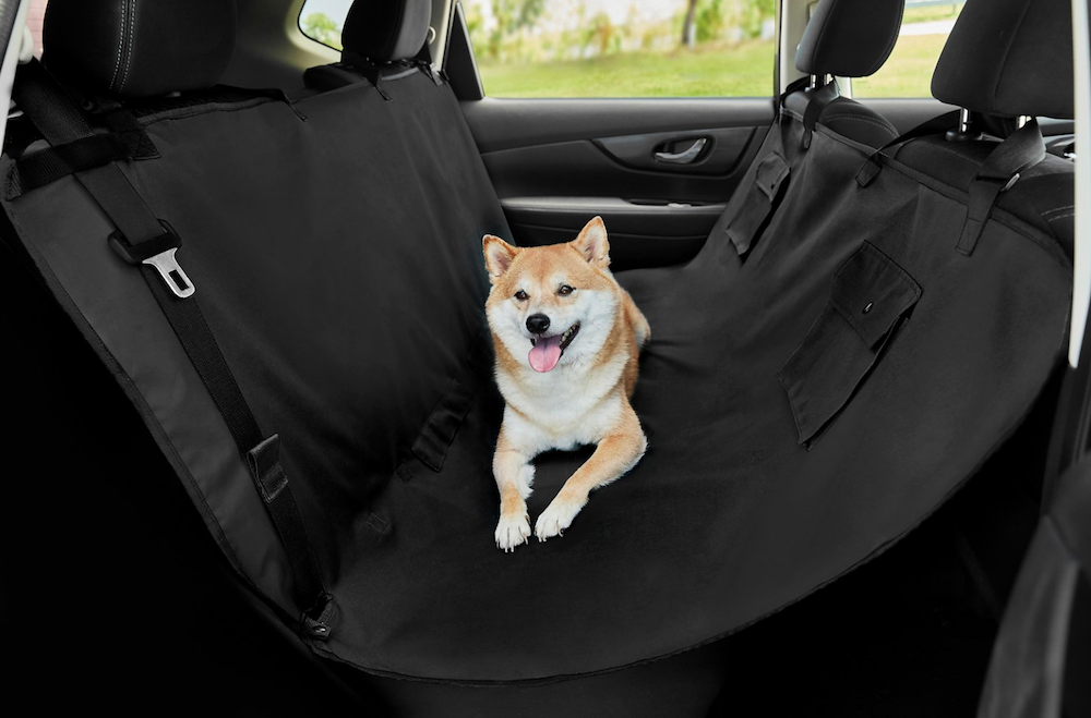 Large dog laying on pet hammock in car